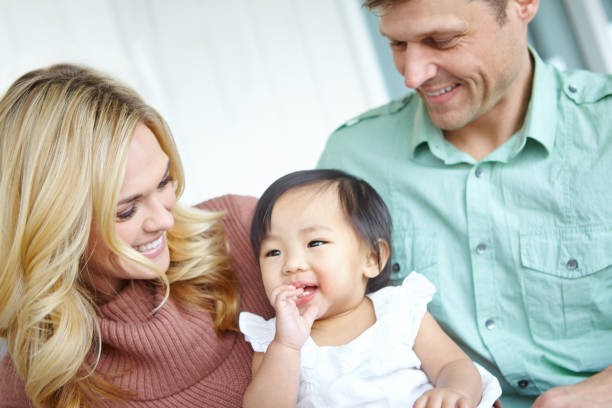 Visuel de parents avec un poupon évoquant l'adoption