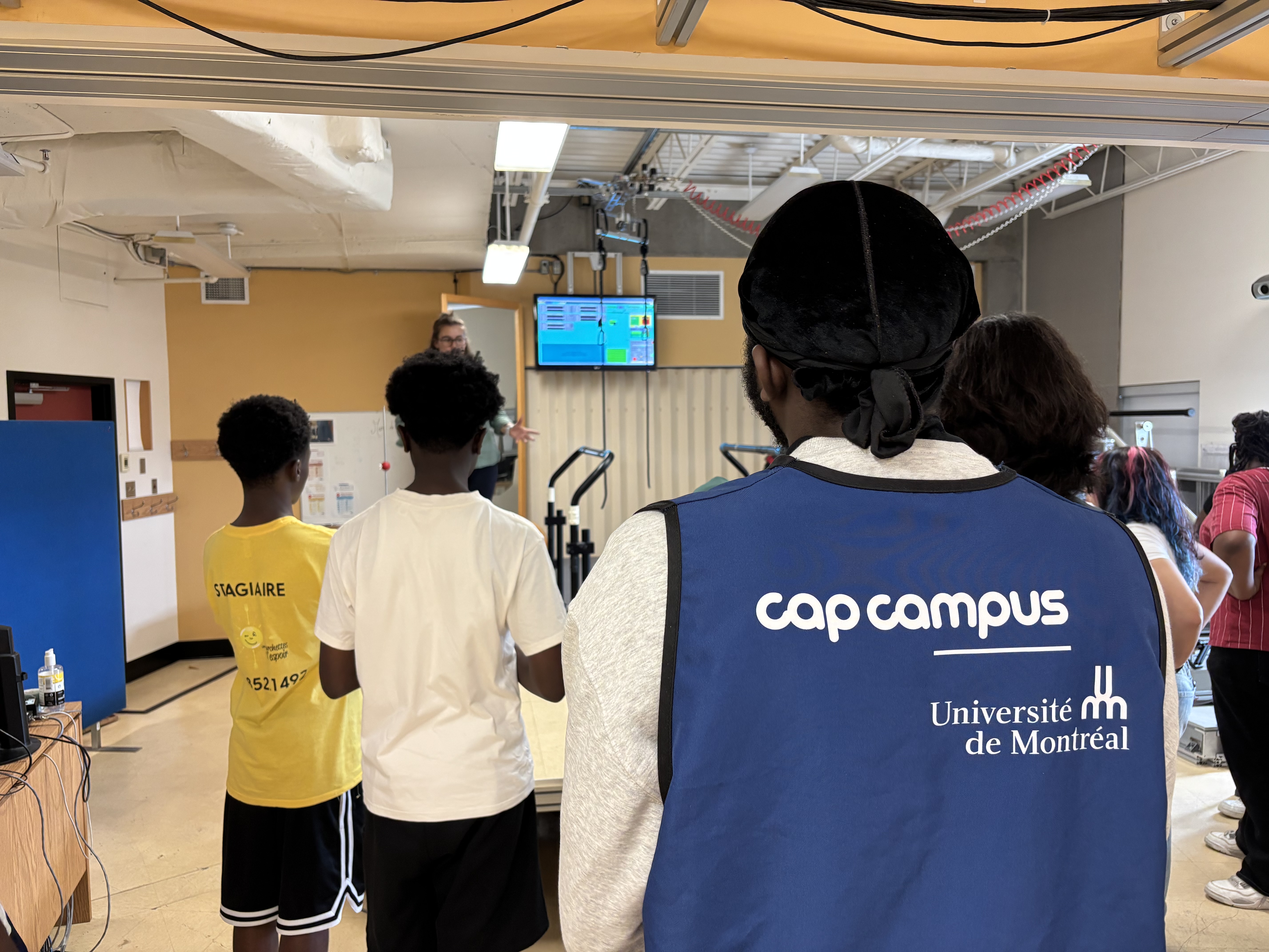 Groupe de jeunes observant un tapis roulant de recherche utilisé pour l’entraînement à la marche et à l’équilibre.